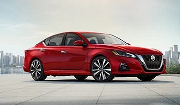 2023 Nissan Altima in red with city in background illustrating last year's 2022 model in Marshall Nissan in Salina KS